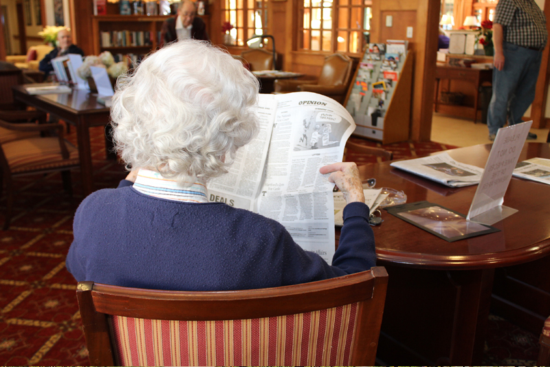 woman reading in the senior living common areas